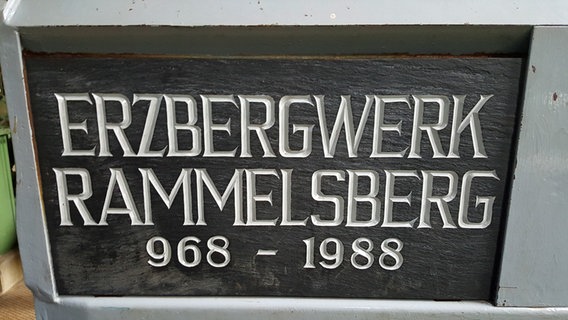 Auf einer Tafel an einem alten Förderwagen steht "Erzbergwerk Rammelsberg 968-1988". © NDR Foto: Kathrin Weber