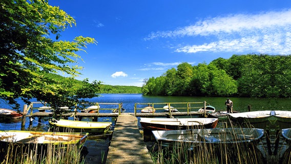 Boats lie on a wooden jetty on the Ukleisee near Eutin in fine summer weather.  © picture-alliance / DUMONT picture archive Photo: Katja Kreder