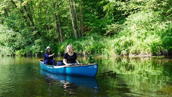 Vanessa Kossen und Britta von Lucke paddeln an einer ruhigen Stelle dicht am Ufer auf der Ilmenau. © NDR Foto: Florian Kruck