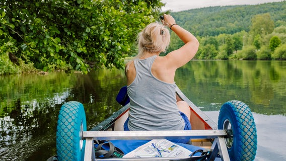 Eine Frau fährt in einem Kanu auf einem Fluss. © imago/photocase Foto: -