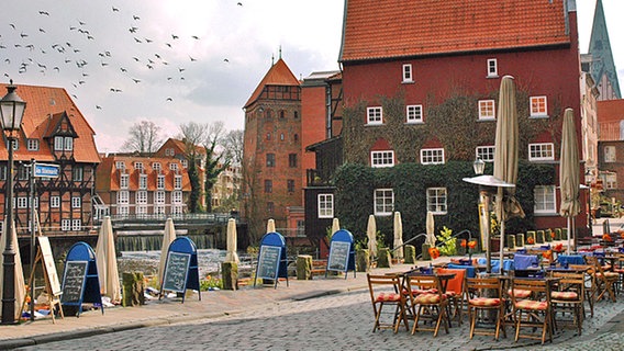 Blick über den Stintmarkt mit Straßengastronomie und auf Schleuse bei der Abtsmühle im Lüneburger Wasserviertel. © Britta Probol 