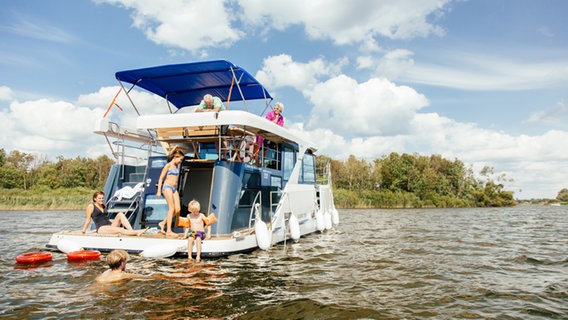 Familie auf einem modernen Hausboot © Tourismusverband Mecklenburg-Vorpommern Foto: TMV/Roth