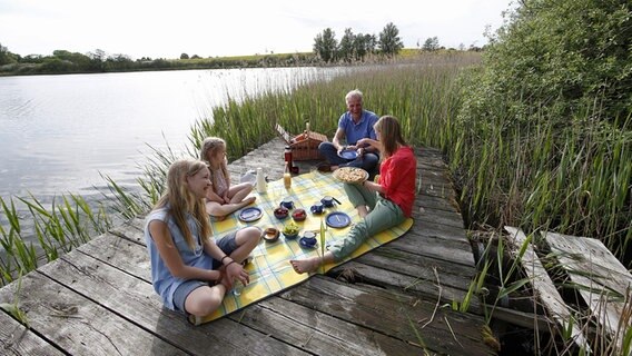 Eine Familie picknickt auf einem Steg. © Tourismusverband Mecklenburg-Vorpommern Foto: TMV/outdoor-visions.com