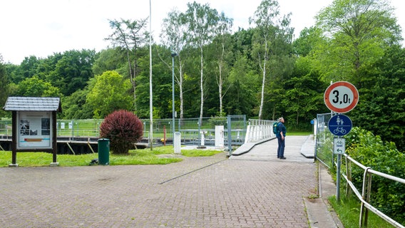 Eine Frau steht auf einer Brücke in einem Schleusenbereich. © NDR Foto: Anja Deuble