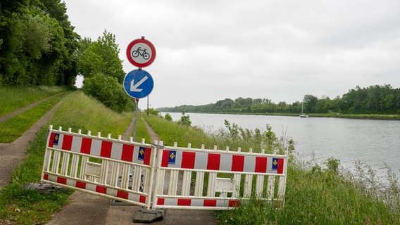 Eine Absperrung und Hinweisschilder an einem Weg am Nord-Ostsee-Kanal. © NDR Foto: Anja Deuble