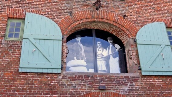 Ein Fenster mit einem historischen Foto im alten Speichergebäude Packhaus im Hafen von Tönning. © NDR Foto: Kathrin Weber