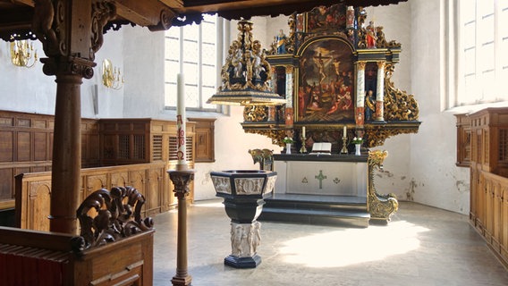 Blick in den Chor der St.-Laurentius-Kirche in Tönning mit Altar und Taufstein. © NDR Foto: Kathrin Weber