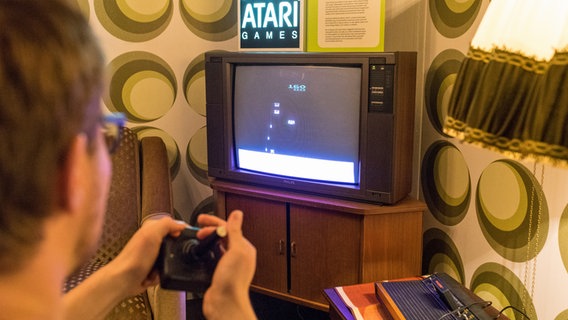 Ein Mann spielt auf einem Röhrenfernseher im Computermuseum Oldenburg ein Atari-Spiel. © Computermuseum Oldenburg 