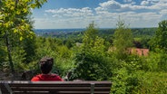 Ein Wanderer macht Rast auf einer Bank am Ahornweg im Osnabrücker Land. © Tourismus-Marketing Niedersachsen Foto: Markus Balkow