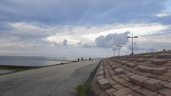 Menschen gehen an der Strandpromenade der Nordseeinsel Baltrum spazieren © NDR Foto: Christina Maciejewski