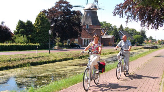 Radfahrer an einem Kanal in Großefehn. © www.ostfriesland.travel 