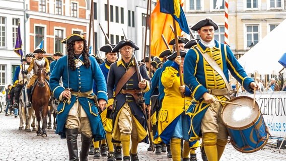 Parade von Männern in historischen Uniformen des schwedischen Militärs. © TZ Wismar Foto: A. Rudolph