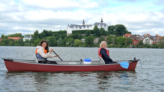 Vanessa Kossen und Britta von Lucke paddeln auf dem Plöner See, im Hintergrund ist das Schloss zu sehen. © NDR Foto: Florian Kruck