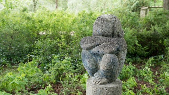 Eine Steinfigur eines hockenden Affens im Hamburger Stadtpark.  Foto: Anja Deuble
