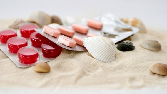 Tabletten und Muscheln am Strand © Fotolia Foto: blende40