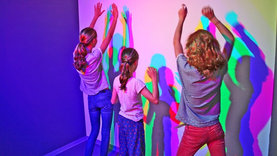 Drei Mädchen erzeugen farbige Lichtspiele im Universum Bremen  . ©  Universum® Bremen 