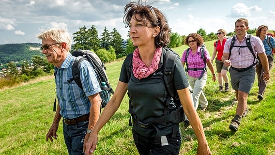 Eine Gruppe Wanderer geht über eine Wiese. © Deutscher Wanderverband Foto: A.Hub