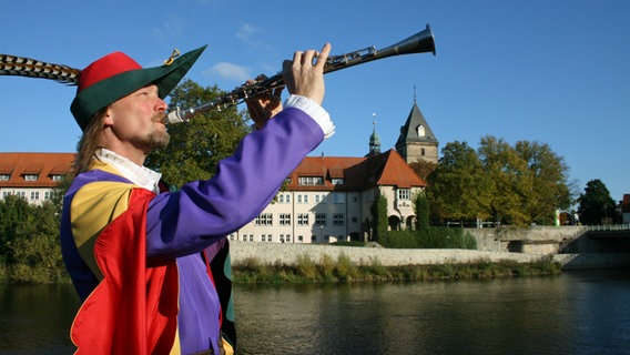 Der Rattenfänger von Hameln posiert mit seiner Flöte an der Weser. © Hameln Marketing und Tourismus GmbH 