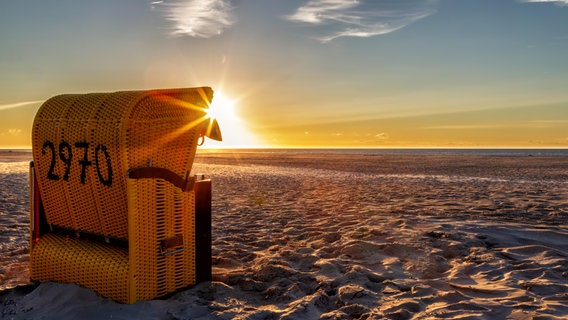 Strandkorb steht einsam am Strand im Sonnenuntergang © Shotshop | DirkR 