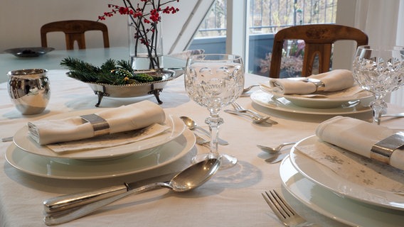 Ein festlich gedeckter Tisch mit weißem Geschirr, Kristallgläsern, Silberbesteck und weißen Stoffservietten. © NDR Foto: Anja Deuble