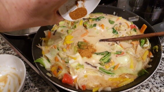 Currypulver hinzufügen für vegetarische Asia-Nudeln © Uwe Leiterer 