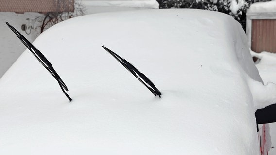 Zwei Scheibenwischer ragen auf einem eingeschneiten Auto aus dem Schnee. © Colourbox Foto: Astrid Gast