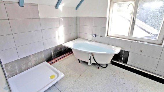 Im noch nicht fertigen Badezimmer steht eine Badewanne. © imago stock&people 