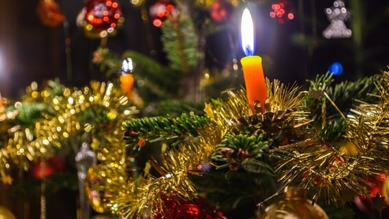 Ein geschmückter Weihnachtsbaum mit echten brennenden Kerzen. © Colourbox Foto: alho007