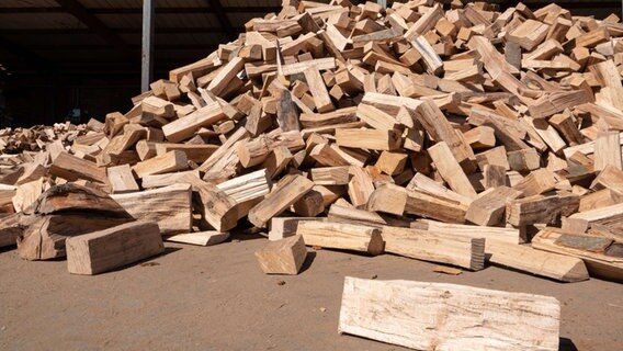 Ein Haufen Brennholz liegt auf einem Hof. © picture alliance/dpa Foto: Melissa Erichsen
