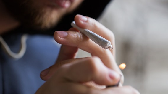Ein Cannabis-Konsument zündet sich einen Joint an © Colourbox Foto: Syda Productions