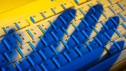 Computer-Tastatur mit Schatten einer Hand © Colourbox Foto: -