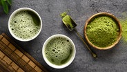 Matcha-Teepulver und Zubehör vor einem dunklen Hintergrund. © picture alliance / Zoonar | Svetlana Khutornaia Foto: Svetlana Khutornaia