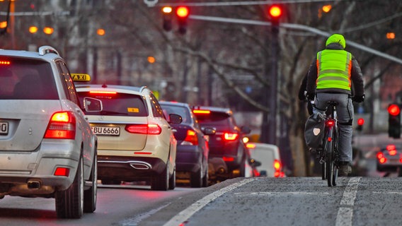 Radfahrer mit Warnweste im abendlichen Stadtverkehr. © picture alliance / dpa Themendienst Foto: Andreas Arnold