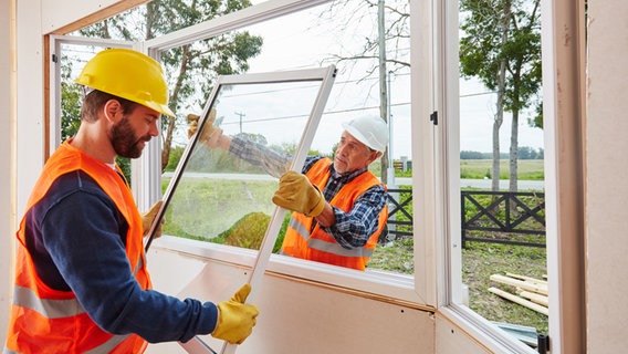 Zwei Handwerker einer Glaserei montieren Fenster im neuen Haus © picture alliance / Zoonar | Robert Kneschke 