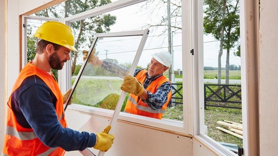 Two craftsmen from a glazing workshop assemble windows in the new house © picture alliance / Zoonar |  Robert Kneske 