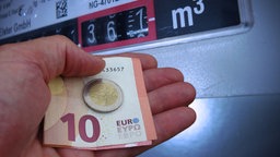 Hand mit Euros vor einem Gaszähler © picture alliance Foto: Frank Hoermann / Sven Simon