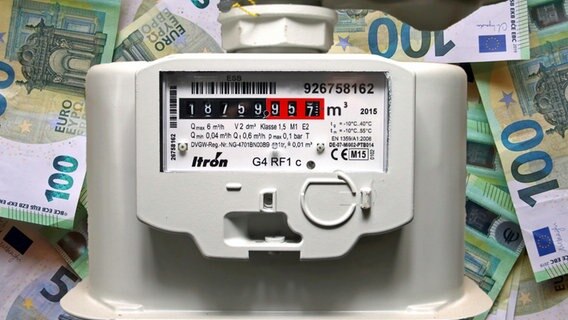 A gas meter with 100 euro bills in the background.  © picture alliance Photo: Ulrich Wagner