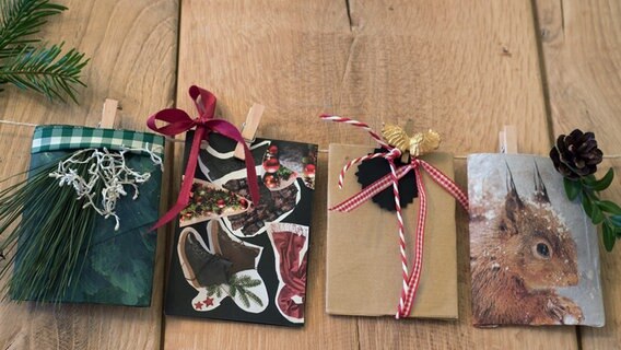 Vier kleine Geschenktaschen für Gutscheine hängen an einer Leine. © NDR Foto: Anja Deuble