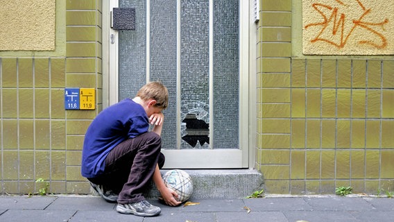 Ein Junge hat eine Glasscheibe in einer Haustuer mit einem Fußball zerschossen. © picture alliance / blickwinkel/W. G. Allgoewer Foto: W. G. Allgoewer