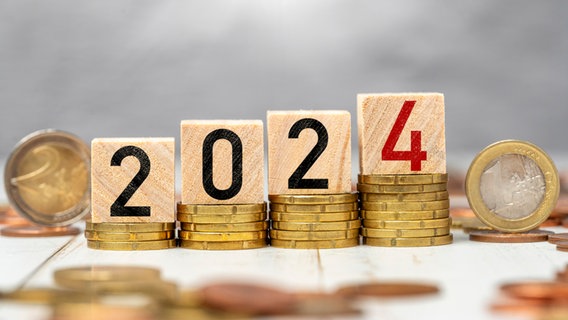 Ein Symbolbild zum Jahreswechsel 2024 mit Münzen und Würfeln. © picture alliance / CHROMORANGE 