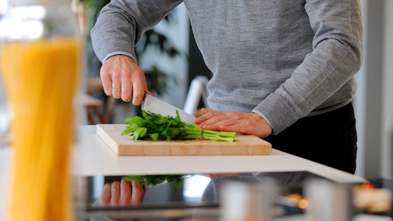 Ein Mann hackt mit einem Küchenmesser Kräuter. © Picture-Alliance / Reality Foto: Frank May