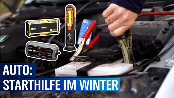 Eine geöffnete Motorhaube. Ein Mann schließt Starthilfekabel an einer Autobatterie an. Daneben sind drei Batteriebooster zu sehen sowie der Text: Auto Starthilfe im Winter. © NDR 