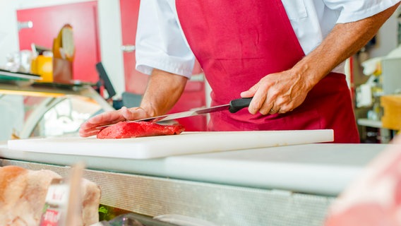 Ein Metzger schneidet ein Stück Fleisch. © Colourbox Foto: Angel Cortijo Nieto