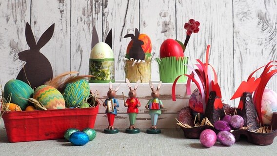 Ein buntes Osternest, Eierbecher aus Klopapierrollen und ein Hühnernest stehen auf einem Tisch. © NDR Foto: Anja Deuble