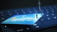 Eine Bankkarte hängt an einem Angelhaken über einer Cumputertastatur. © picture alliance / Zoonar Foto: magann