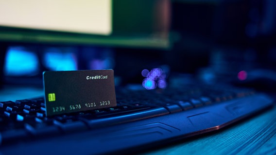 Eine Bankkarte steckt in einer Cumputertastatur. © IMAGO / Zoonar 
