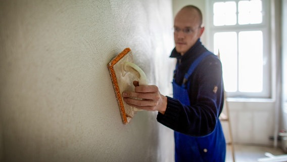 Handwerker verputzt eine Wand in einem Altbau. © picture alliance / photothek Foto: Thomas Koehler