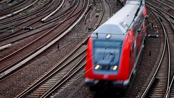 Eine fahrende Regionalbahn auf einem Schienennetz © picture alliance/dpa Foto: Christian Charisius