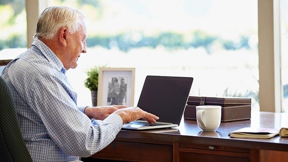 Ein Senior sitzt am Schreibtisch vor einem Laptop © Fotolia.com Foto: Monkey Business