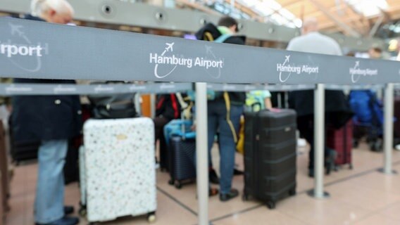 Reisende stehen an einem Check-in-Schalter am Flughafen Hamburg an © dpa-Bildfunk Foto: Bodo Marks
